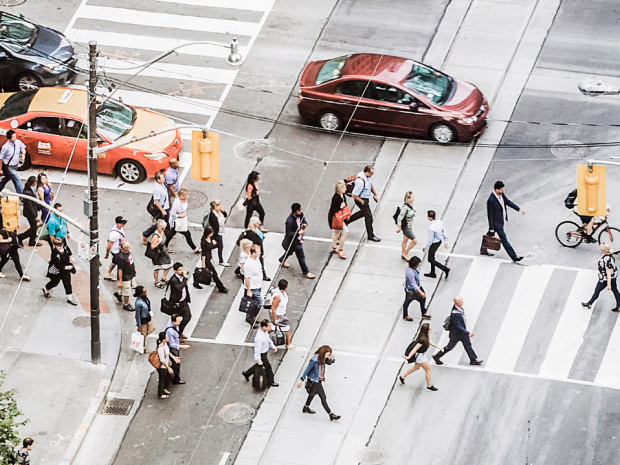 A large group of people walking along a crosswalk